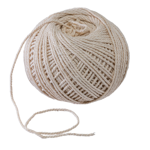 Cream-colored cotton twine ball. Natural fiber yarn spool. Crafting supply for knitting or crochet.