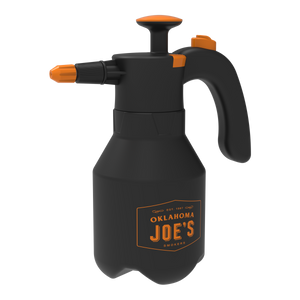 Black plastic spray bottle with orange accents. Garden sprayer for plants.